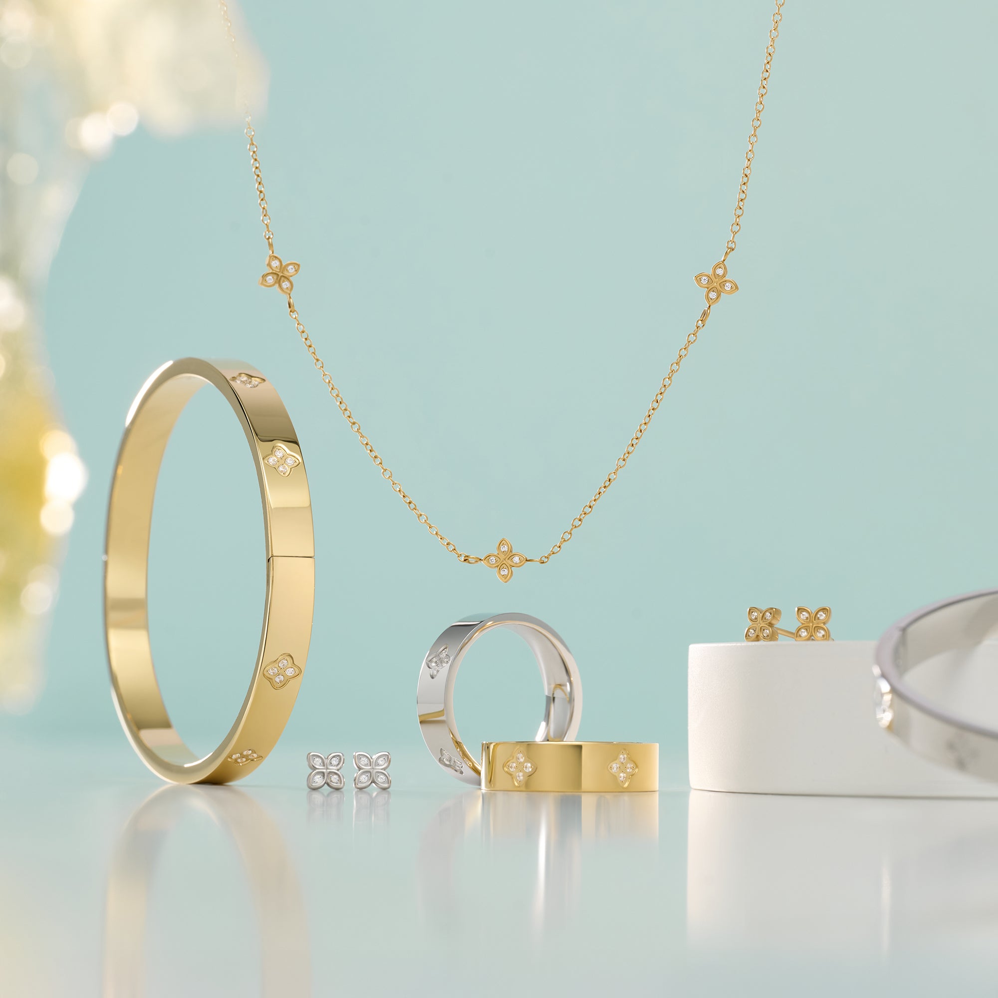 Gold and silver stainless steel jewelry set including bangle bracelet, rings, necklace and stud earrings with pavé flower details, hypoallergenic jewelry for sensitive skin, tarnish free, waterproof and affordable luxury in Canada.