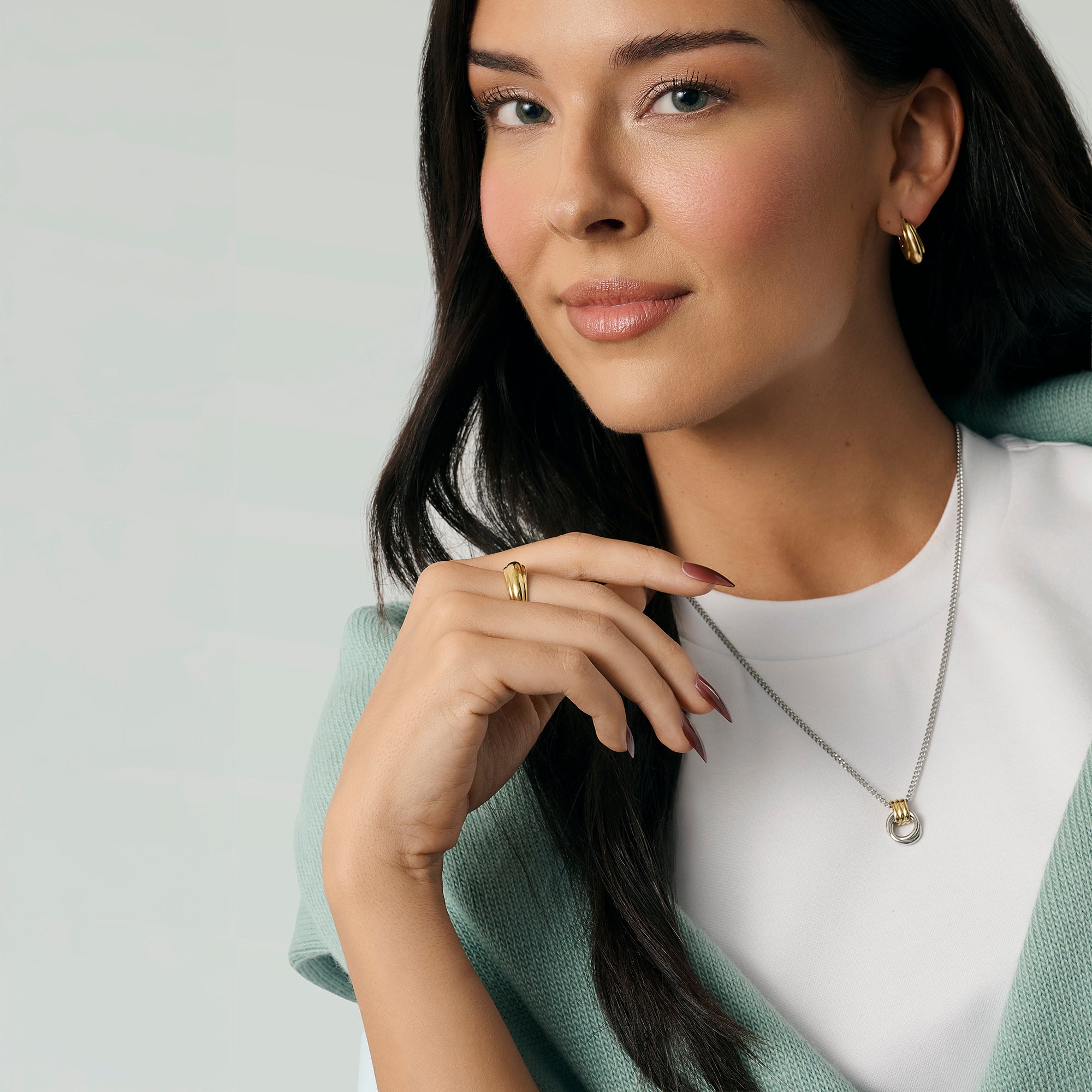 A close-up lifestyle shot of a woman wearing a two-tone chain necklace with a pendant, along with gold earrings. Waterproof, stainless steel and allergy free. By MIAJWL.

Photo lifestyle en gros plan d'une femme portant un collier à chaîne deux tons avec pendentif, ainsi que des boucles d'oreilles dorées. Résistant à l'eau, en acier inoxydable et hypoallergénique. Par MIAJWL.
